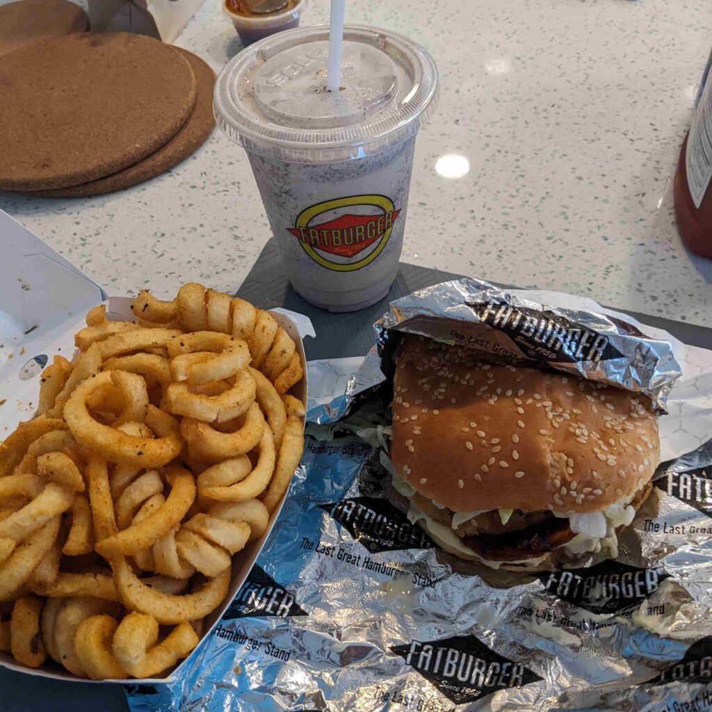 Bacon cheeseburger, curly fries and chocolate milkshake from Fat Burger